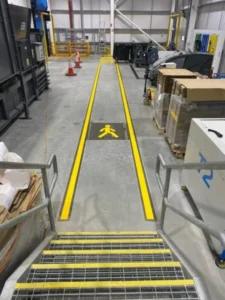UV line marking pedestrian walkway with yellow lines and safety step nosings inside a warehouse