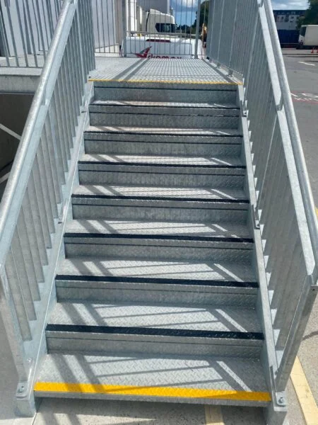 UV line marking pedestrian walkway with yellow lines and safety step nosings inside a warehouse